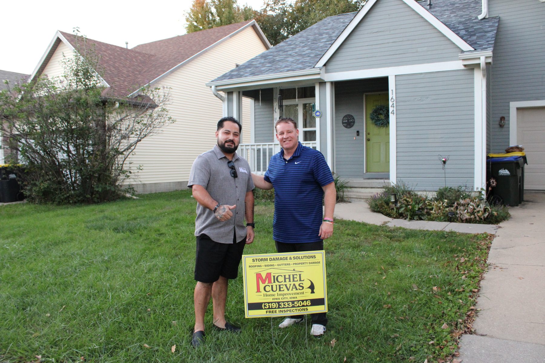 Adrian of Michel Cuevas Home Improvement with homeowner Brad outside his Iowa City home